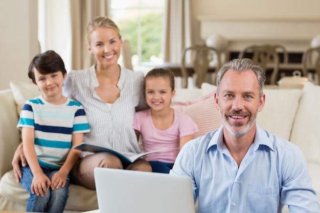 Portret van ouders en kinderen zittend op de Bank in de woonkamer