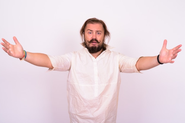 Foto portret van overgewicht bebaarde man met snor en lang haar, gekleed in een wit overhemd tegen een witte muur