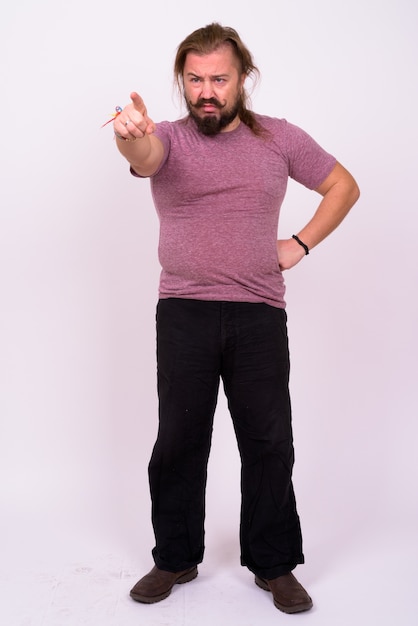 Portret van overgewicht bebaarde man met snor en lang haar tegen witte muur