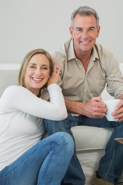 Portret van paar met koffiekop in woonkamer