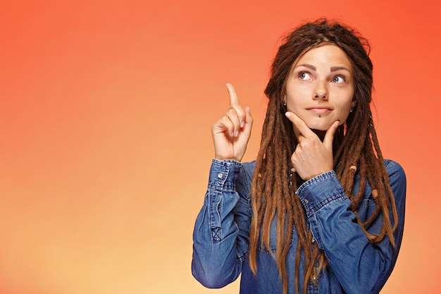 Portret van peinzende jonge vrouw die een goed idee heeft