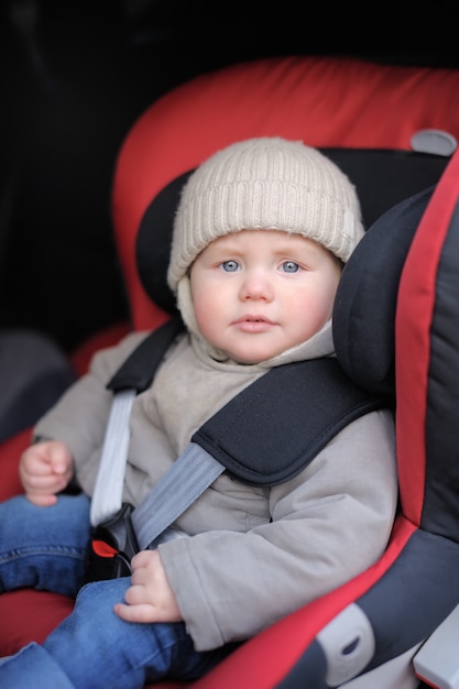 Portret van peuter jongen zit in autostoel