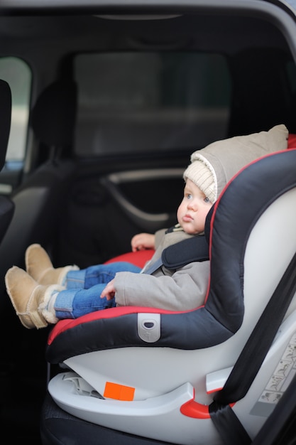 Portret van peuter jongen zit in autostoel