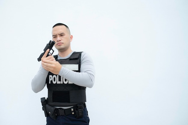 Portret van politie houdt pistool in de hand op witte achtergrondKnappe Aziatische agent