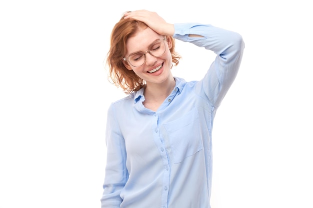 Portret van positief roodharig meisje in zakelijk overhemd verheugt zich emotioneel en voelt zich gelukkig geïsoleerd op een witte achtergrond reclamebanner