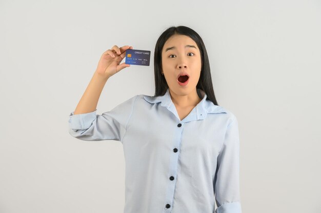 Portret van positieve jonge aziatische vrouw die creditcard goed humeur salaris toont geïsoleerd op een witte achtergrond