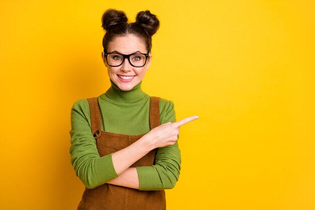 Portret van positieve meisje punt vinger copyspace heldere glans kleur achtergrond