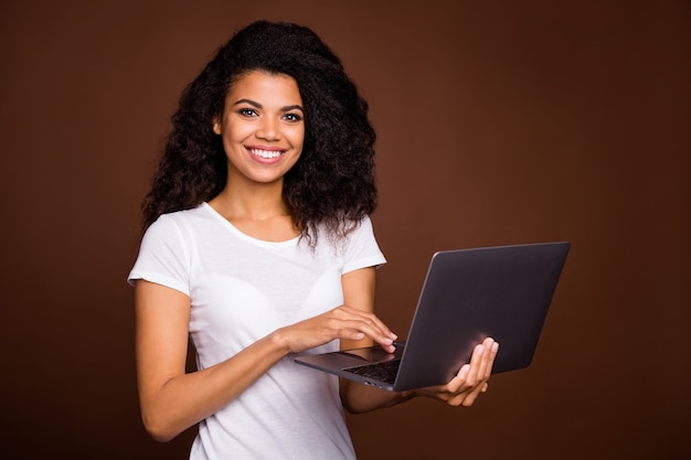 Portret van positieve vrolijke afro-amerikaanse meisje computerchat gebruiken met vrienden dragen casual stijl outfit.