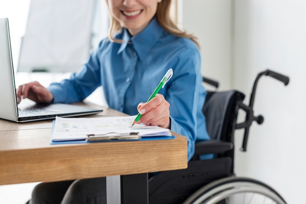 Portret van positieve vrouw die op het kantoor werkt