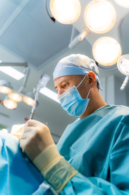 Portret van professionele chirurg met medische apparatuur. Zelfverzekerde chirurg die met een medisch masker opereert.