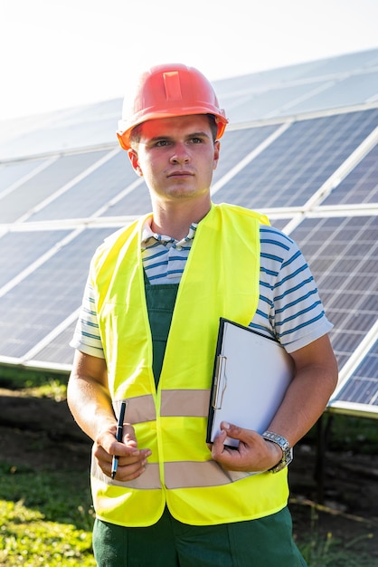 Foto portret van professionele elektricien in het zonnepaneelstation van de helm