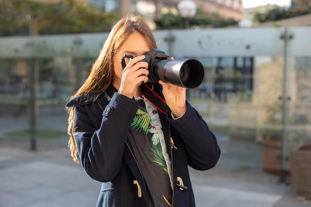 Portret van professionele vrouwelijke fotograaf op straat fotograferen op een camera. Fotoshoot fotosessie in de stad