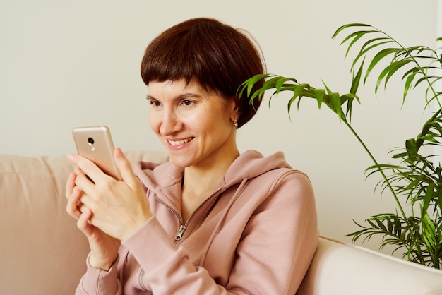 Portret van rijpe vrouw die sociale media op vrouw van middelbare leeftijd van de mobiele telefoon kijkt