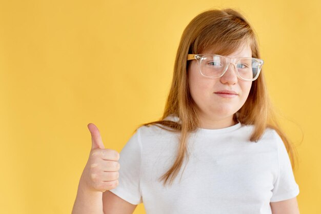 Portret van roodharige tienermeisje op gele achtergrond