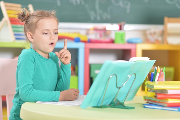 Portret van schattig gelukkig schoolmeisje huiswerk