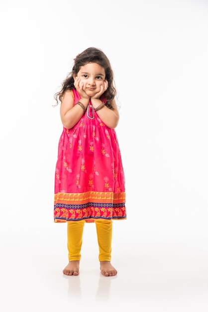 Portret van schattig klein Indiaas meisje model, zittend geïsoleerd op witte achtergrond