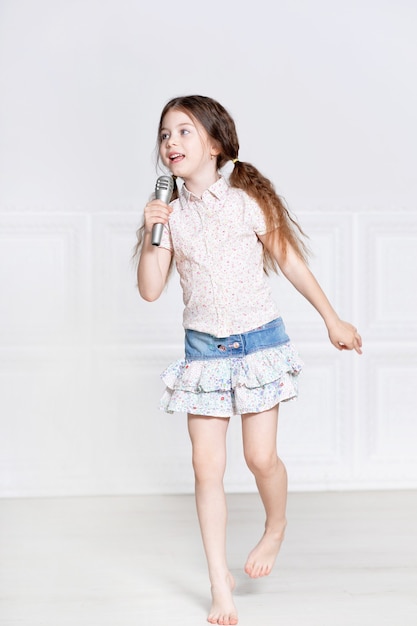 Portret van schattig klein meisje in mooie jurk zingen