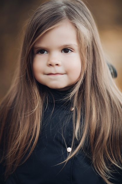 Portret van schattig klein meisje met lang haar en lichtbruine ogen medium close-up. Aanbiddelijk gezicht van vrouwelijk kind met perfecte huid en natuurlijke schoonheid die kalmteemotie hebben