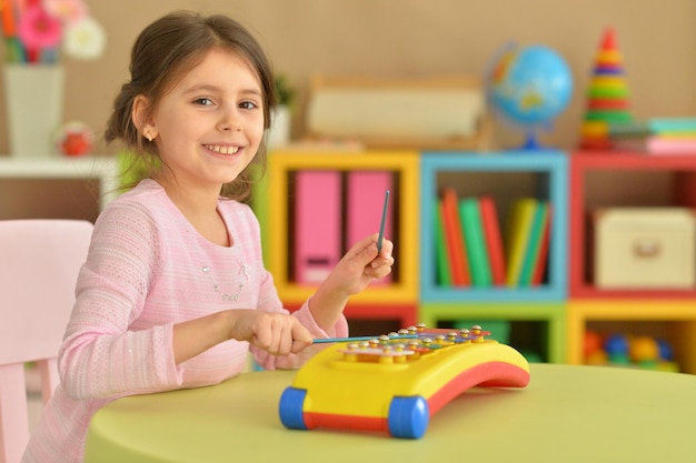 Portret van schattig meisje dat speelt met muzikaal speelgoed