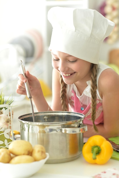 Portret van schattig meisje koken op keuken en luisteren naar muziek