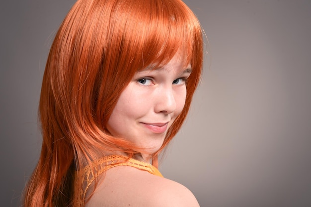 Portret van schattig meisje met rood haar poseren in studio