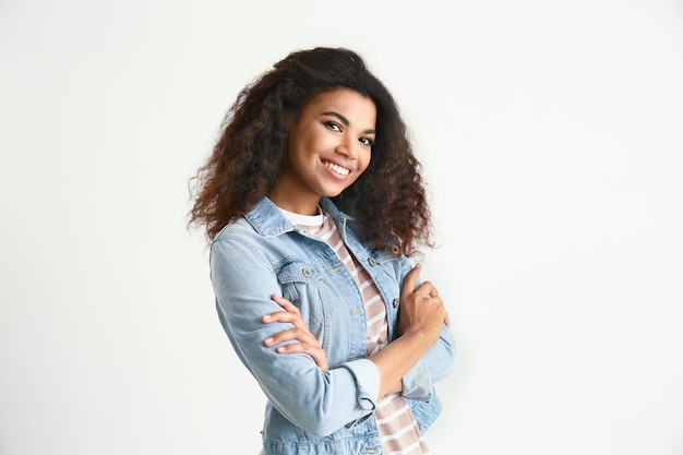 Portret van schattige Afro-Amerikaanse vrouw op lichte ondergrond