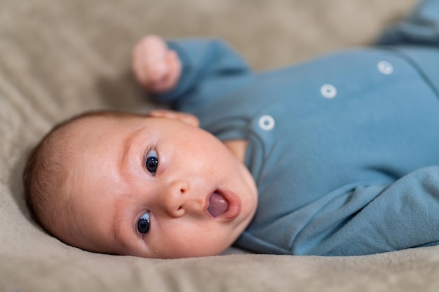 Portret van schattige babyjongen die op zijn zij op bed ligt Eerste fotoshoot Pasgeboren baby