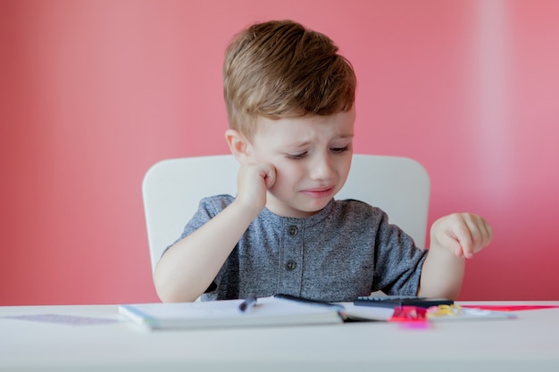 Portret van schattige jongen jongen thuis huiswerk maken