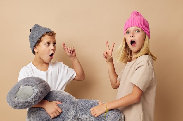 Portret van schattige kinderen die naast het poseren van speelgoedemoties op een geïsoleerde achtergrond staan