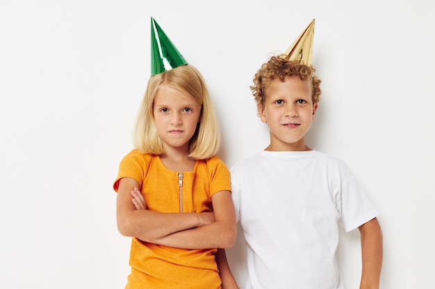 Portret van schattige kinderen poseren emoties vakantie kleurrijke caps lichte achtergrond