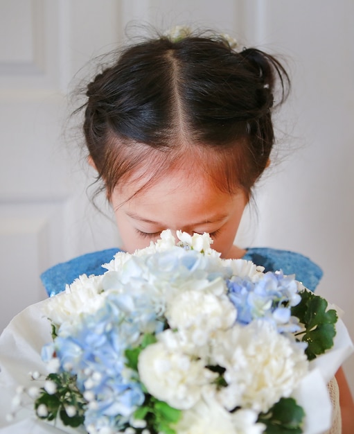 Portret van schattige kleine kind meisje ruikende boeket van bloemen