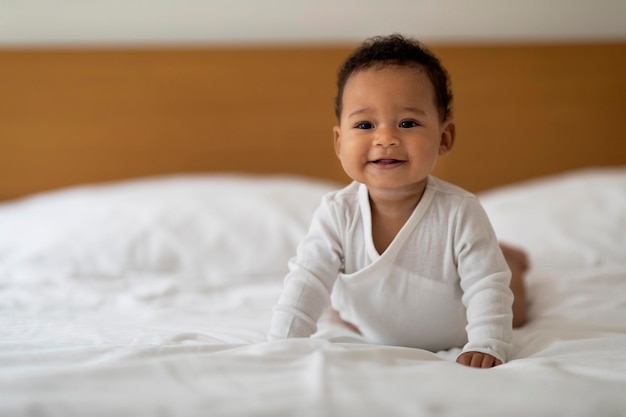 Portret van schattige zwarte pasgeboren baby ontspannen in bed thuis