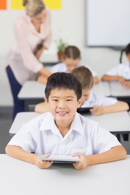 Portret van schooljongen die digitale tablet gebruiken