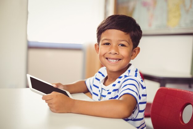 Portret van schooljongen die digitale tablet in klaslokaal gebruiken