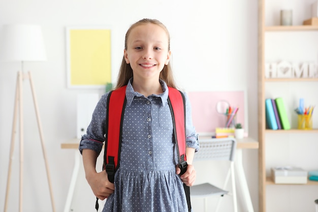 Portret van schoolmeisje met een rugzak en briefpapier