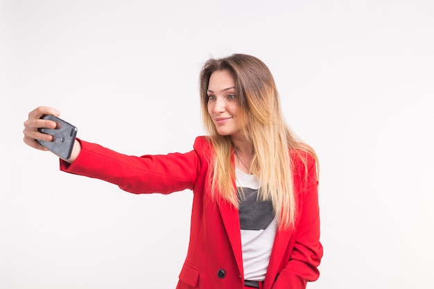 Portret van selfie die mooie jonge vrouw in rood jasje maakt
