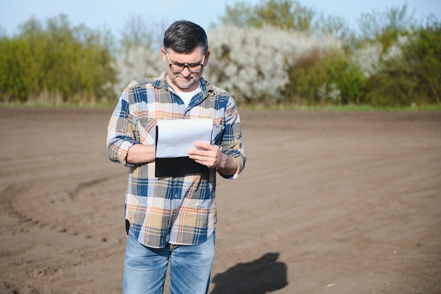 Portret van senior boer met een bril in het veld