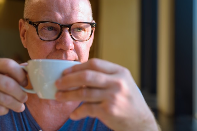 Portret van senior knappe Scandinavische toeristische man ontspannen in de coffeeshop