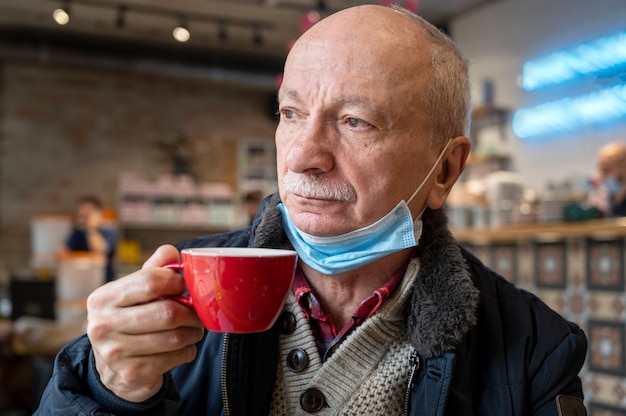 Portret van senior man genieten van kopje koffie in café