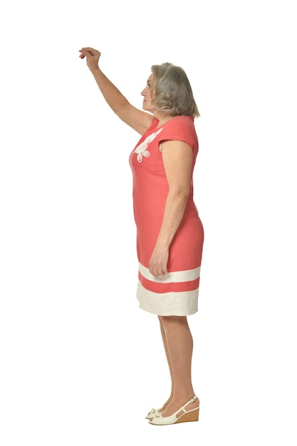 Portret van senior vrouw in rode jurk op witte achtergrond