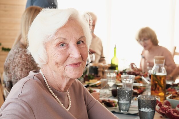 Portret van senior vrouw met wit haar kijken ze heeft een diner met haar familie aan tafel