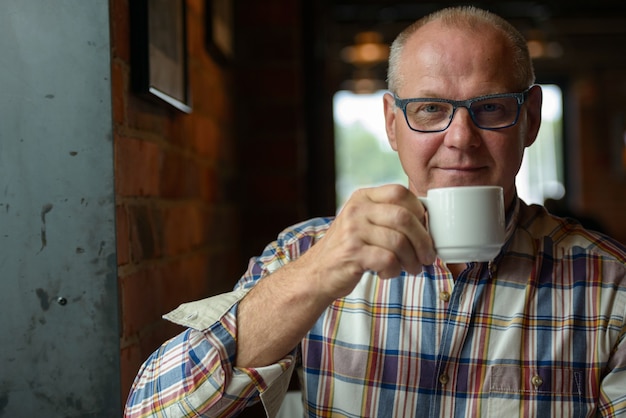 Portret van senior zakenman koffie drinken in de coffeeshop