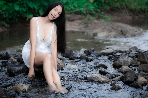 Portret van sexy aziatische vrouw bij de waterval Fris voelen aan de rivierThaise vrouw ontspant zich op het platteland