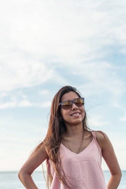 Portret van sexy jonge vrouw die camera met zonsonderganglicht bekijkt