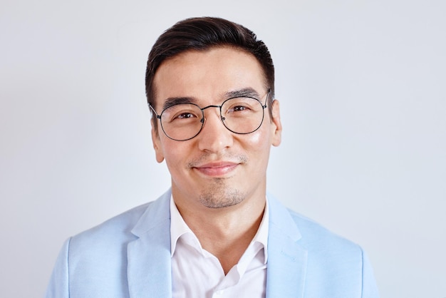 Portret van slimme vriendelijke lachende Kazachse man in glazen gekleed in pak in kantoor op witte achtergrond. Aziatische knappe succesvolle zakenman
