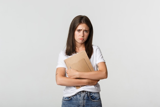 Portret van somber en ellendig schattig meisje met notitieboekjes