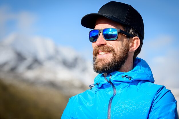 Portret van sportieve bebaarde man in de bergen