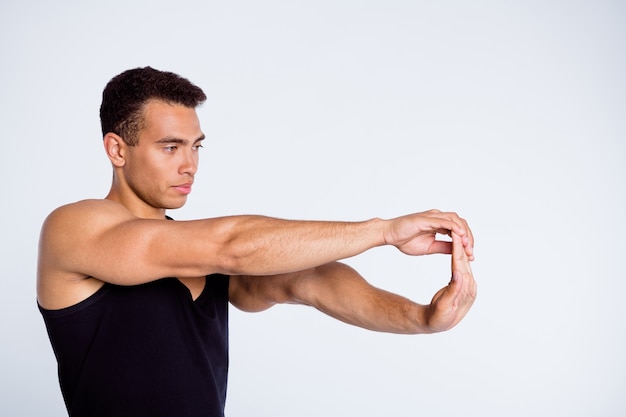 Portret van sportieve kerel kampioen teamspeler stretch armen gewrichten geïsoleerd over grijze achtergrond