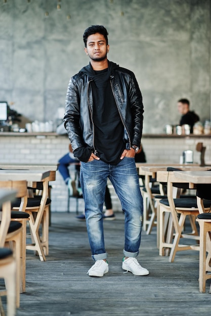 Portret van stijlvolle en casual jonge Aziatische man dragen op lederen jas tijd doorbrengen in café
