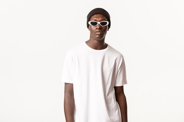 Portret van stijlvolle en coole Afro-Amerikaanse jonge kerel in beanie en zonnebril